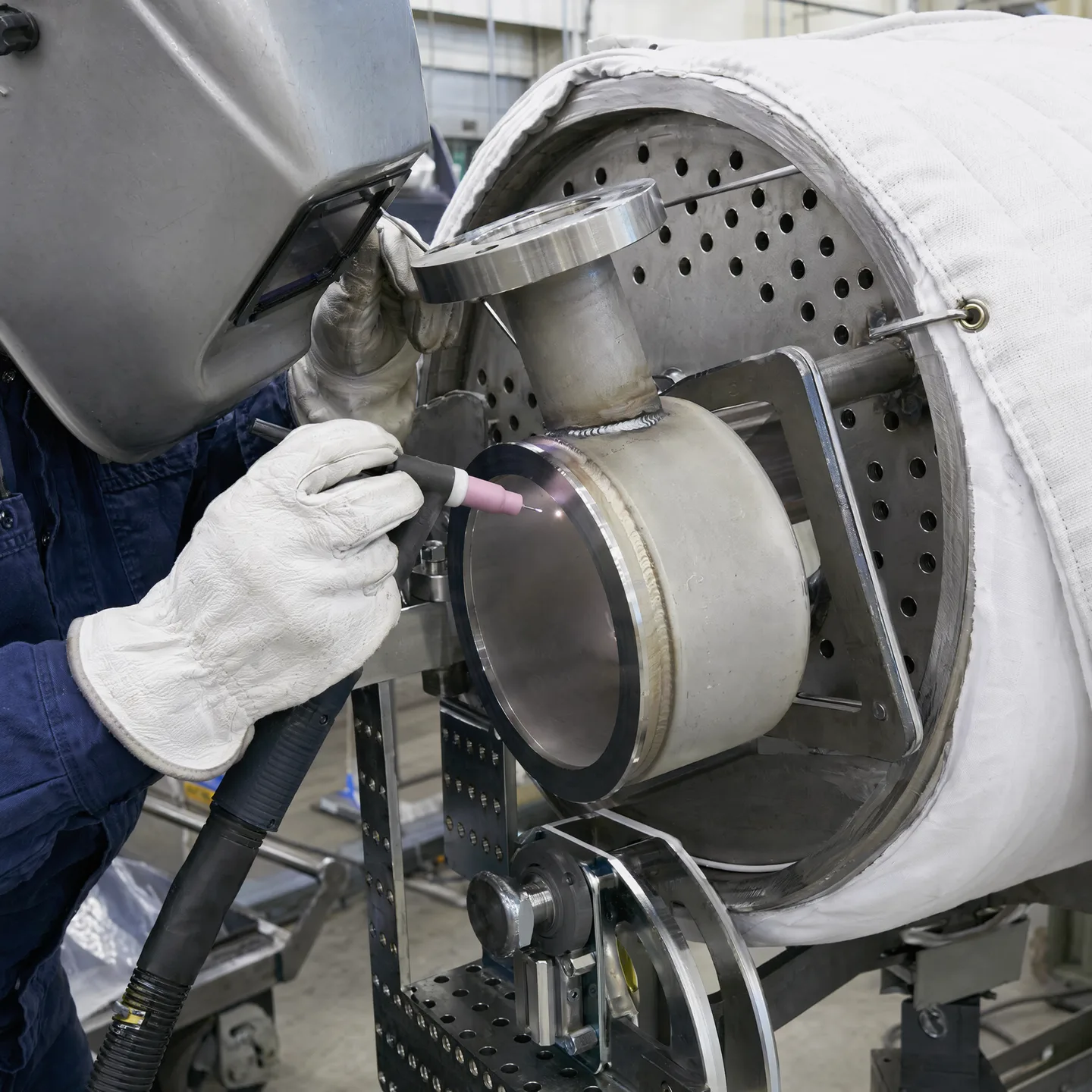 Fabricator carrying out a controlled connection weld on an exchanger assembly